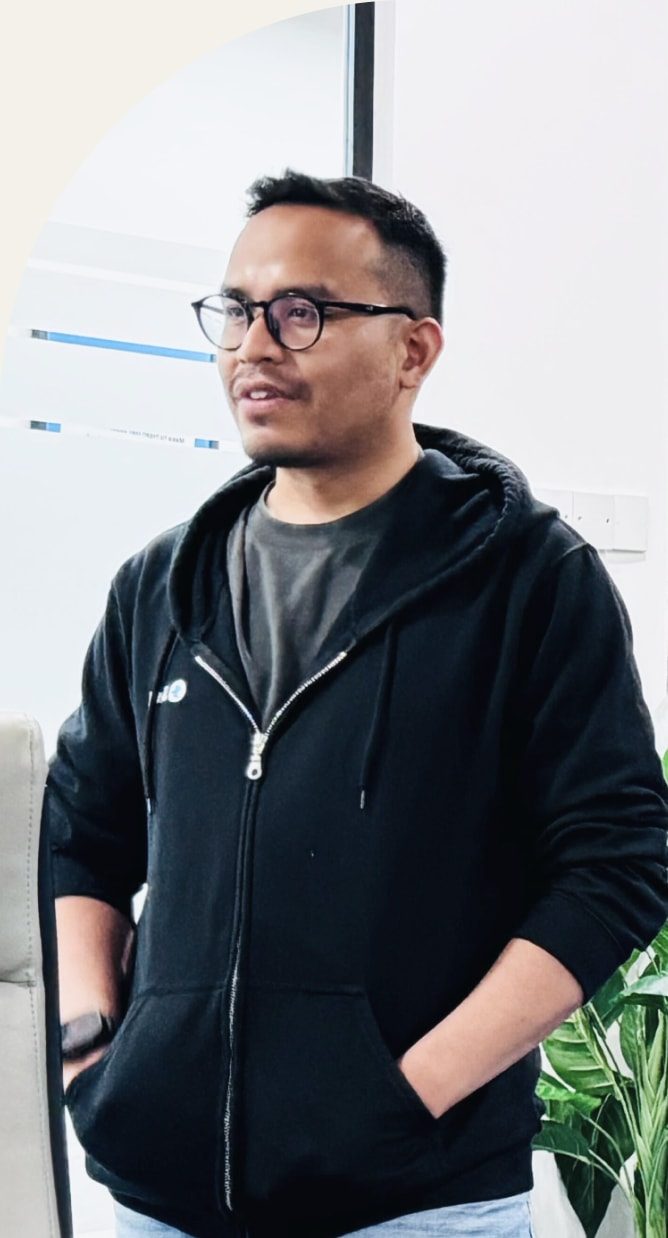 Mujib standing in a black hoodie, smiling