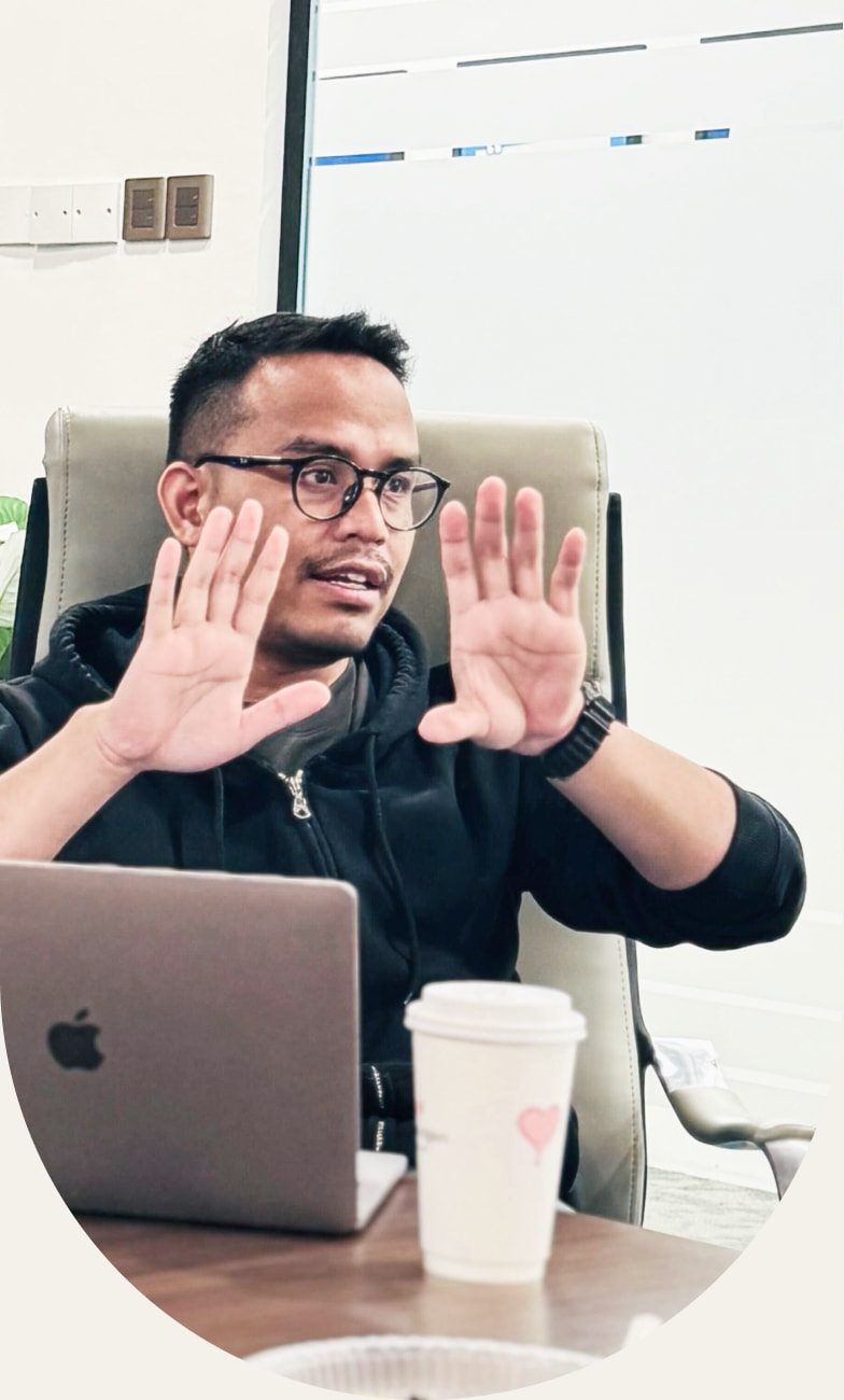 Mujib at his desk, hands raised mid-explanation