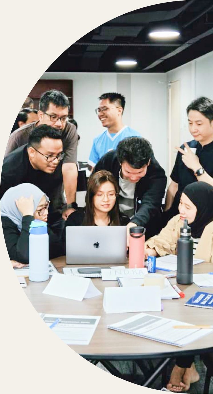 Mujib with his design team, gathered around a laptop during a workshop
